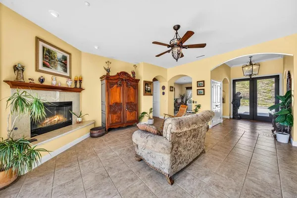 a living room with furniture a fireplace and a floor to ceiling window
