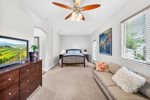 a living room with furniture a flat screen tv and a floor to ceiling window