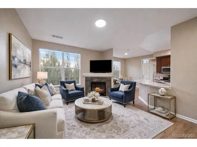 a living room with furniture a fireplace and a flat screen tv