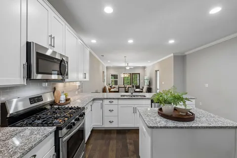 a kitchen with stainless steel appliances granite countertop a sink stove and cabinets