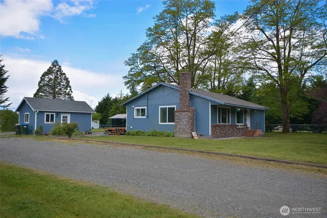 a front view of a house with a yard and trees