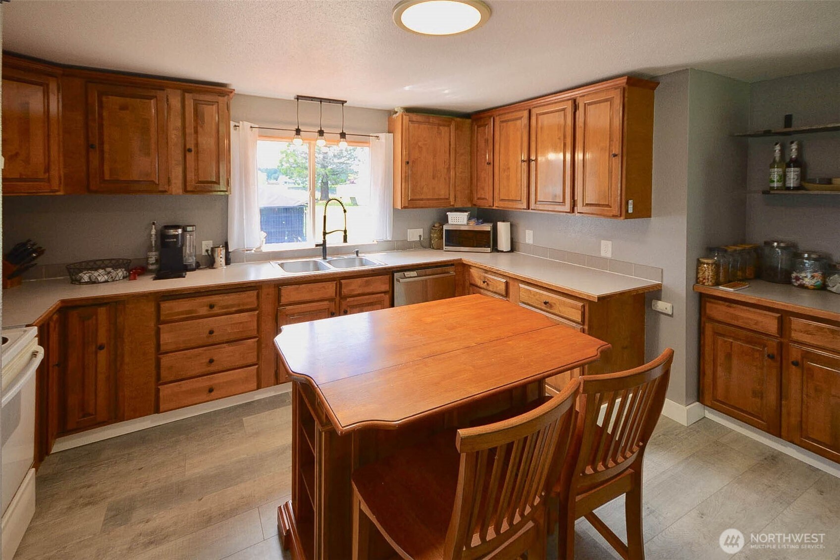 20005 Carper Road Southwest Rochester, WA 98579 - Photo 18 of 35 a kitchen with a stove a sink a microwave and wooden cabinets