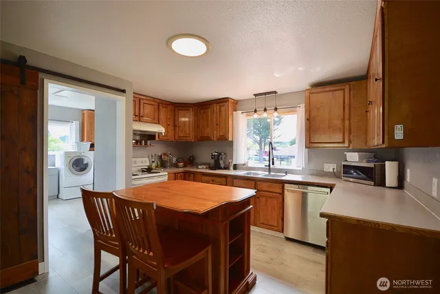 a kitchen with a table chairs refrigerator and cabinets