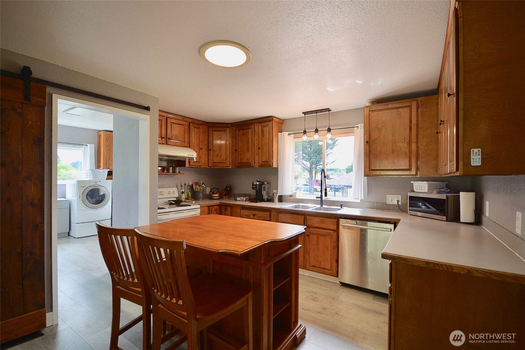 20005 Carper Road Southwest Rochester, WA 98579 - Photo 19 of 35 a kitchen with stainless steel appliances granite countertop a table chairs sink refrigerator and cabinets