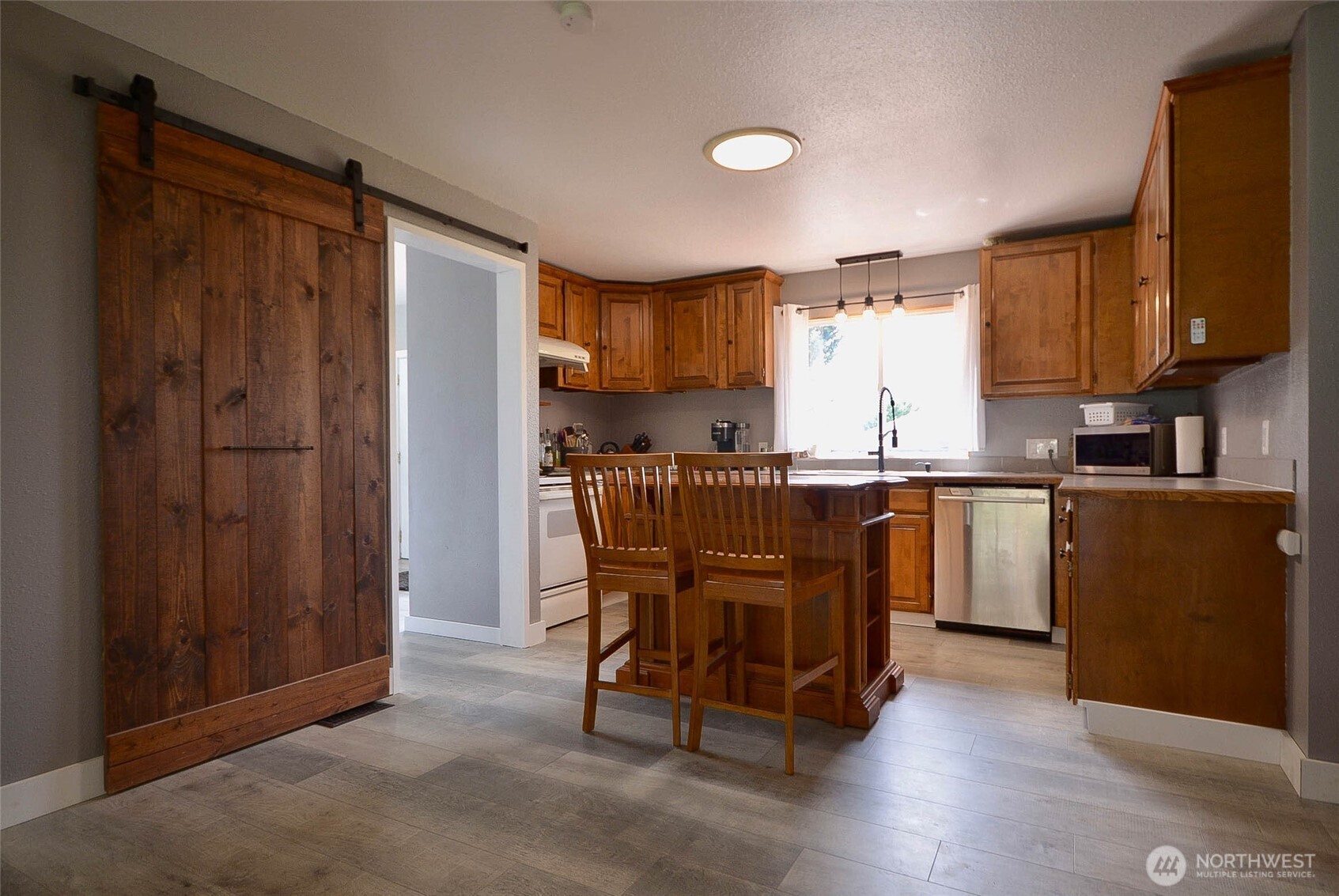 20005 Carper Road Southwest Rochester, WA 98579 - Photo 20 of 35 a kitchen with a table chairs refrigerator and cabinets