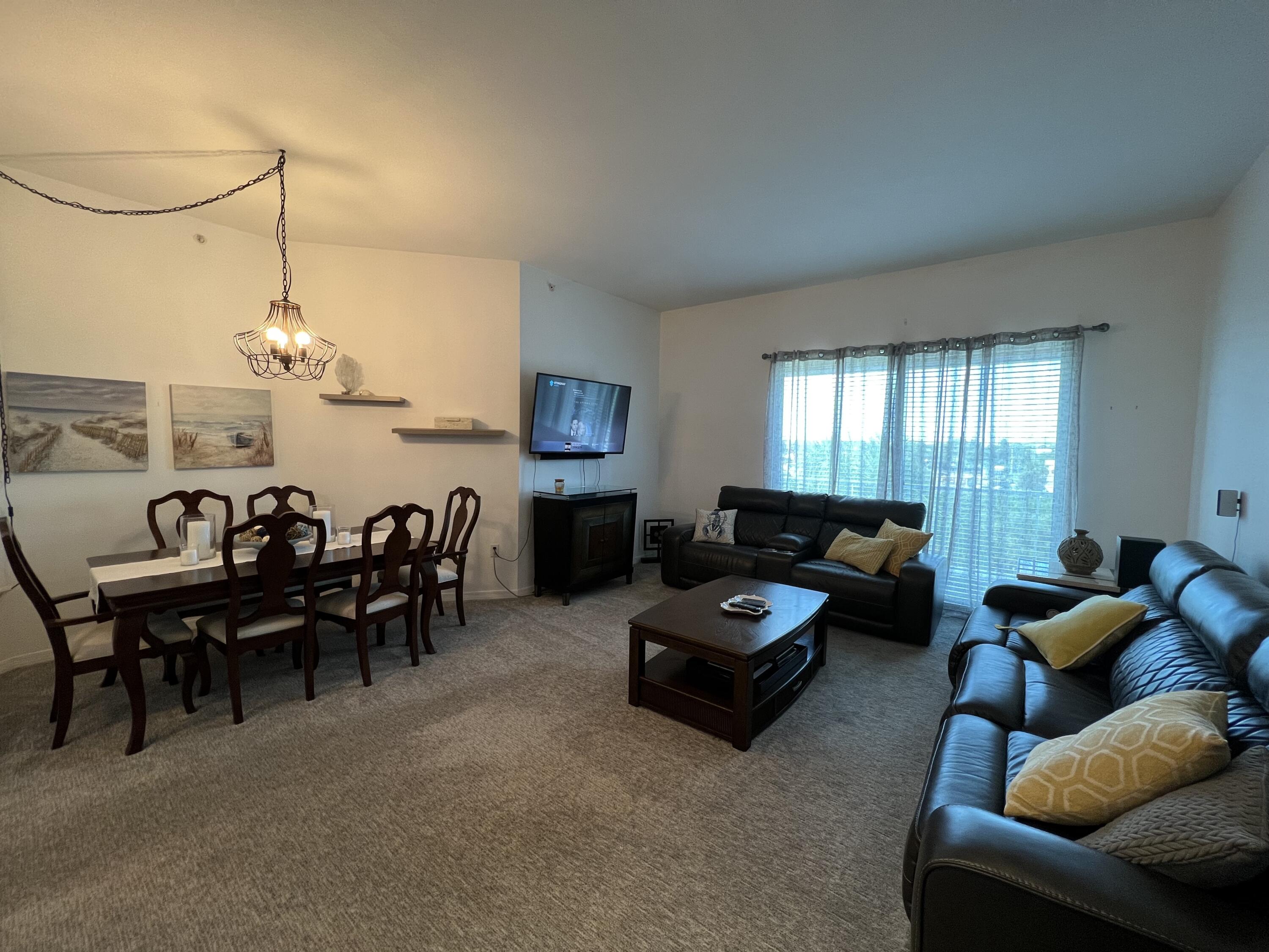 802 West Windward Way, Unit PH15 Lantana, FL 33462 - Photo 17 of 34 a living room with furniture a chandelier and a dining table