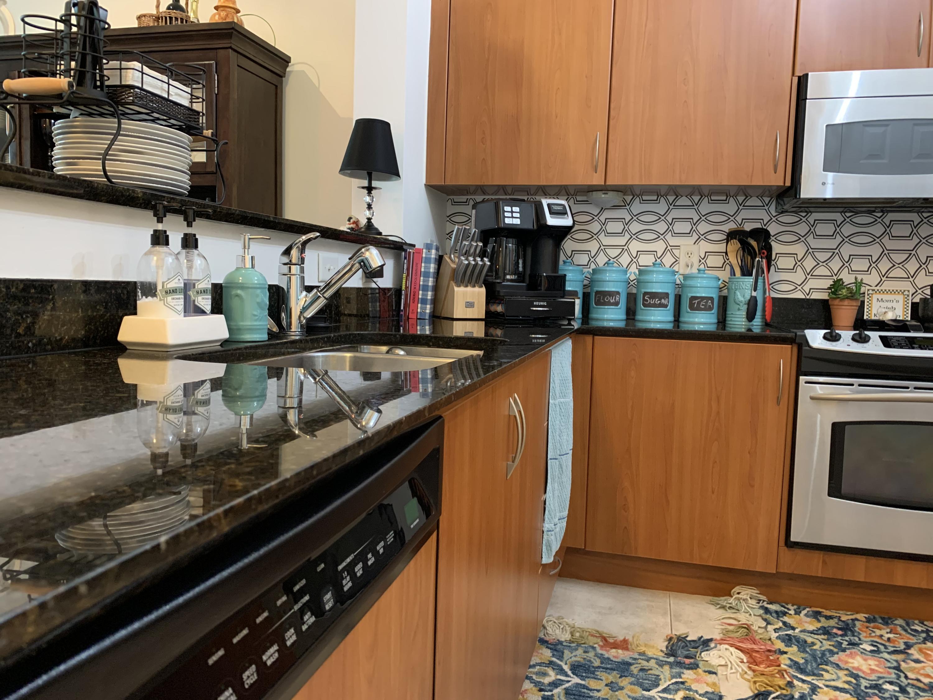 802 West Windward Way, Unit PH15 Lantana, FL 33462 - Photo 23 of 34 a kitchen with stainless steel appliances granite countertop a sink stove and refrigerator