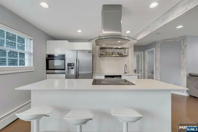 a large kitchen with stainless steel appliances a large counter top