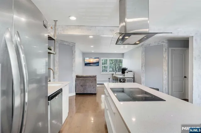 a kitchen with stainless steel appliances a refrigerator sink and stove