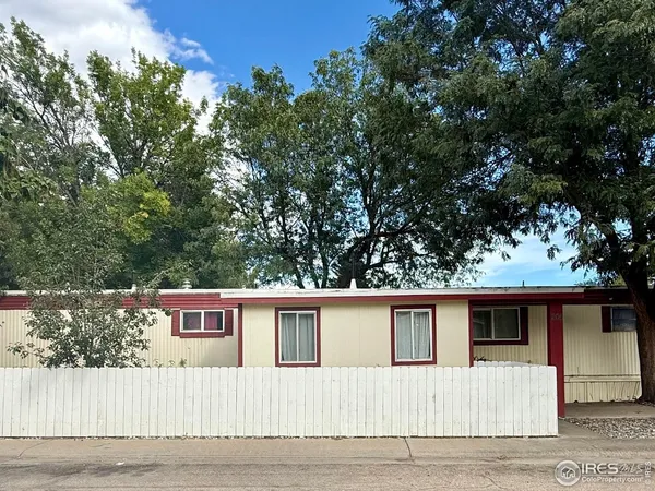 a front view of a house with a tree