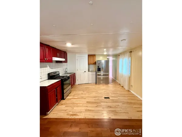 a kitchen with stainless steel appliances kitchen island granite countertop a refrigerator and a stove top oven