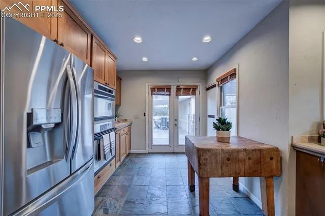 a kitchen with stainless steel appliances granite countertop a refrigerator and a stove top oven