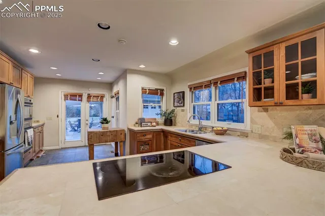 a kitchen with stainless steel appliances granite countertop a sink and a refrigerator