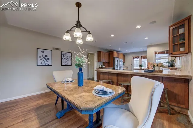 a view of a dining room with furniture a chandelier and wooden floor