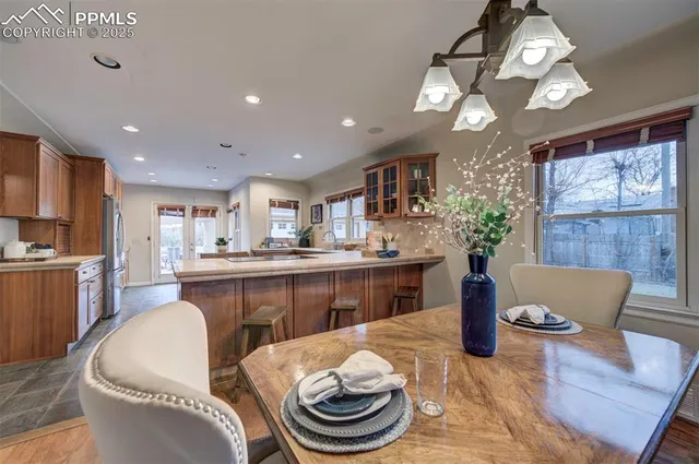 a kitchen with a dining table chairs sink and granite counter top