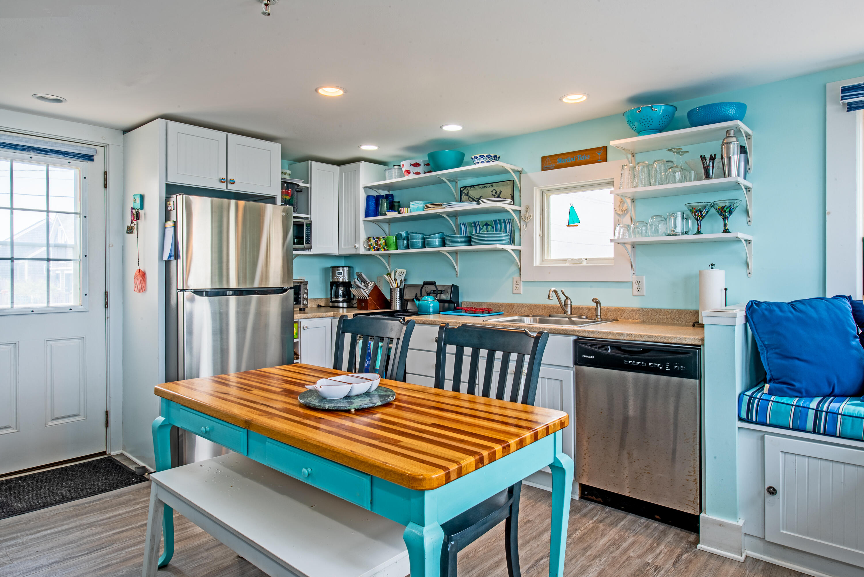 522 Shore Road, Unit 5 Truro, MA 02666 - Photo 17 of 28 a kitchen with stainless steel appliances granite countertop a refrigerator a sink dishwasher a stove and a dining table with wooden floor