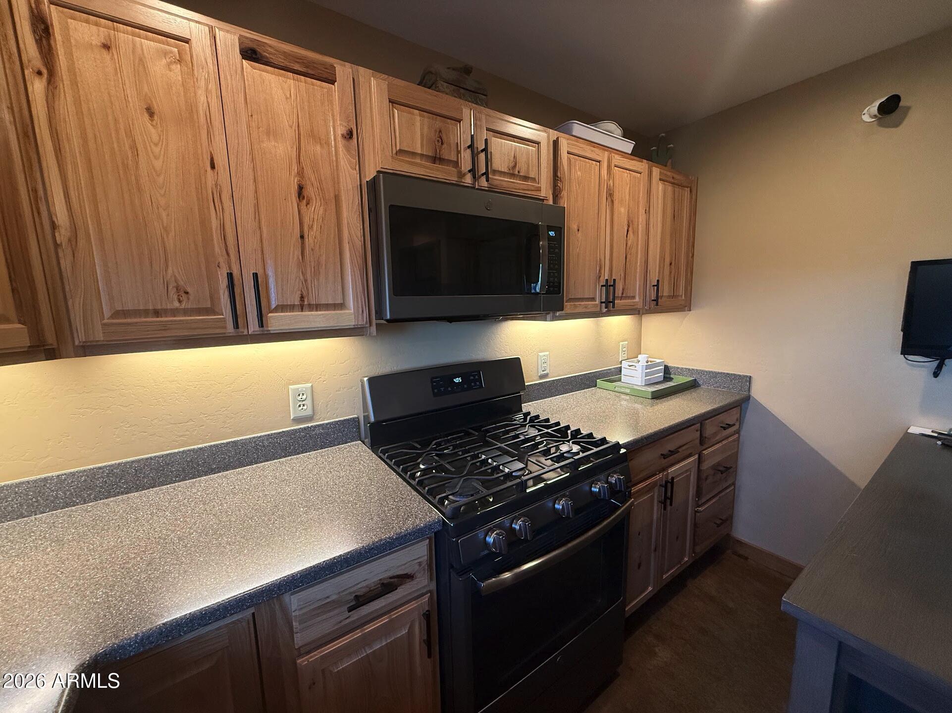 35723 South Amalia Road Eloy, AZ 85131 - Photo 9 of 34 a kitchen with stainless steel appliances a stove a microwave and a counter space