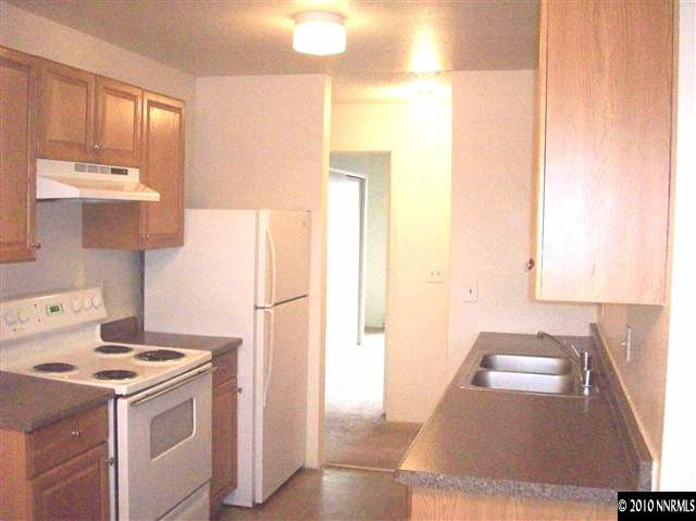3880 East Leonesio Drive, Unit C2 Reno, NV 89512 - Photo 2 of 7 a kitchen with a sink a stove and white cabinets