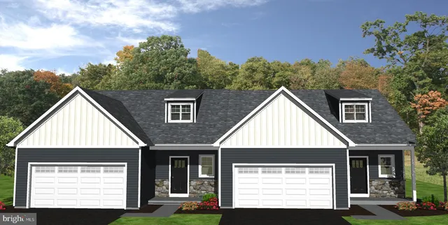 a view of a house with a small yard plants and large tree