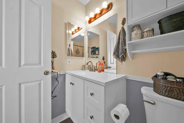 a bathroom with a sink vanity mirror and toilet