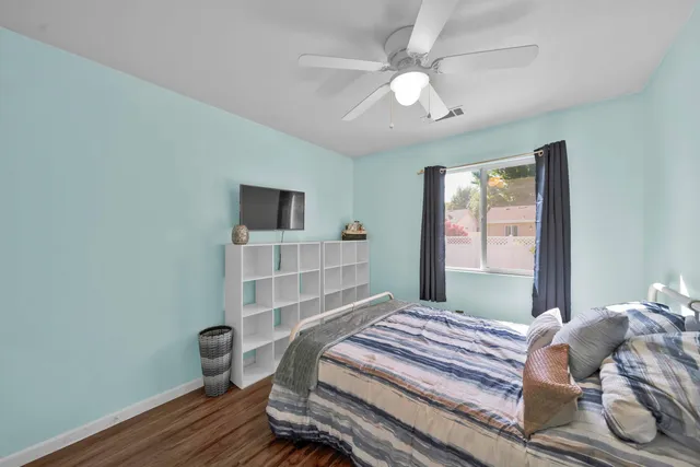 a bedroom with a bed and a flat tv screen on the dresser