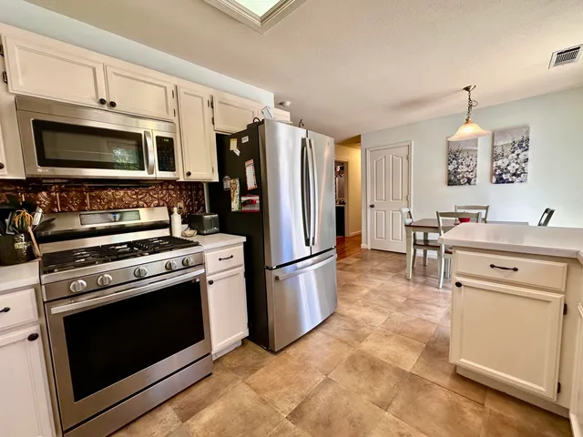 a kitchen with stainless steel appliances a stove microwave and a refrigerator