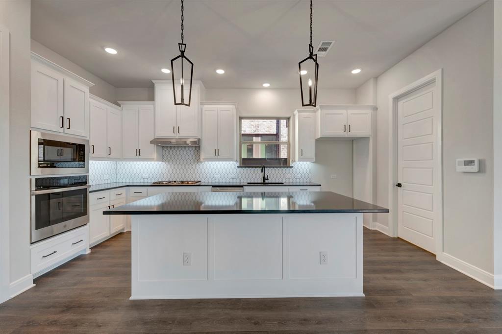 1857 Lightner Road Van Alstyne, TX 75495 - Photo 14 of 29 a kitchen with kitchen island stainless steel appliances a sink and wooden floor