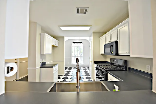 a kitchen with stainless steel appliances granite countertop a sink a stove counter space and cabinets