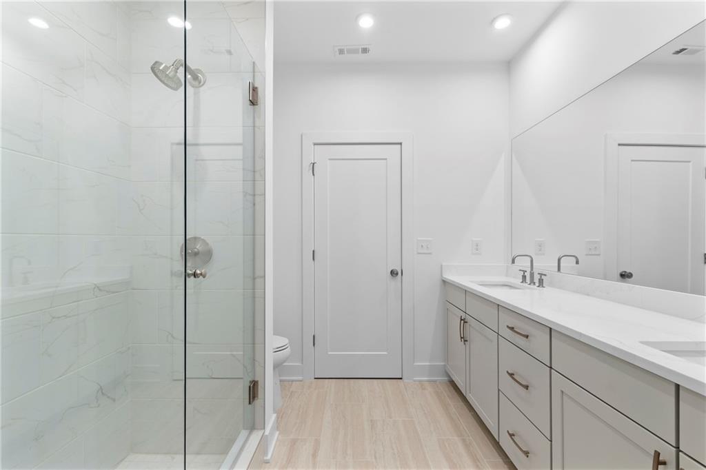 201 New Street, Unit 1204 Decatur, GA 30030 - Photo 19 of 26 a spacious bathroom with a double vanity sink a mirror and shower