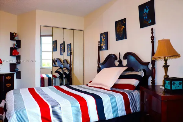 a bedroom with a bed and dresser next to a window