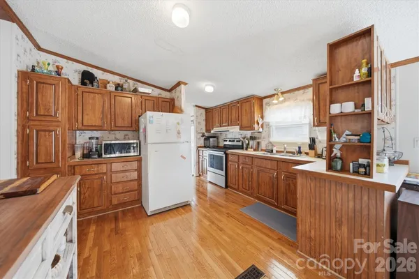 a kitchen with granite countertop a refrigerator stove top oven and sink