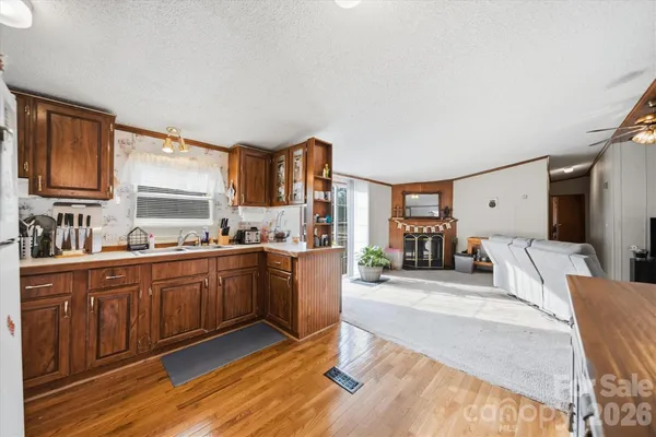 a large living room with stainless steel appliances granite countertop a couch cabinets and a window