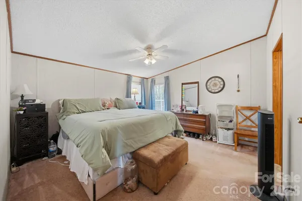 a spacious bedroom with a bed and a chandelier