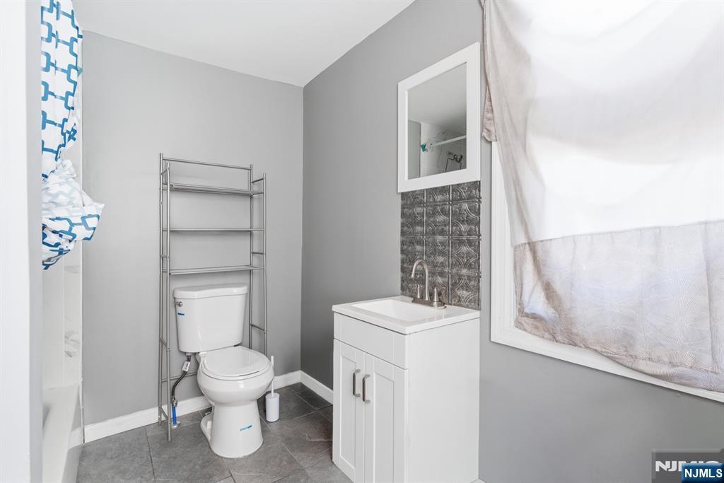 61 Cutler Street Newark, NJ 07104 - Photo 11 of 22 a white toilet sitting next to a bathroom sink
