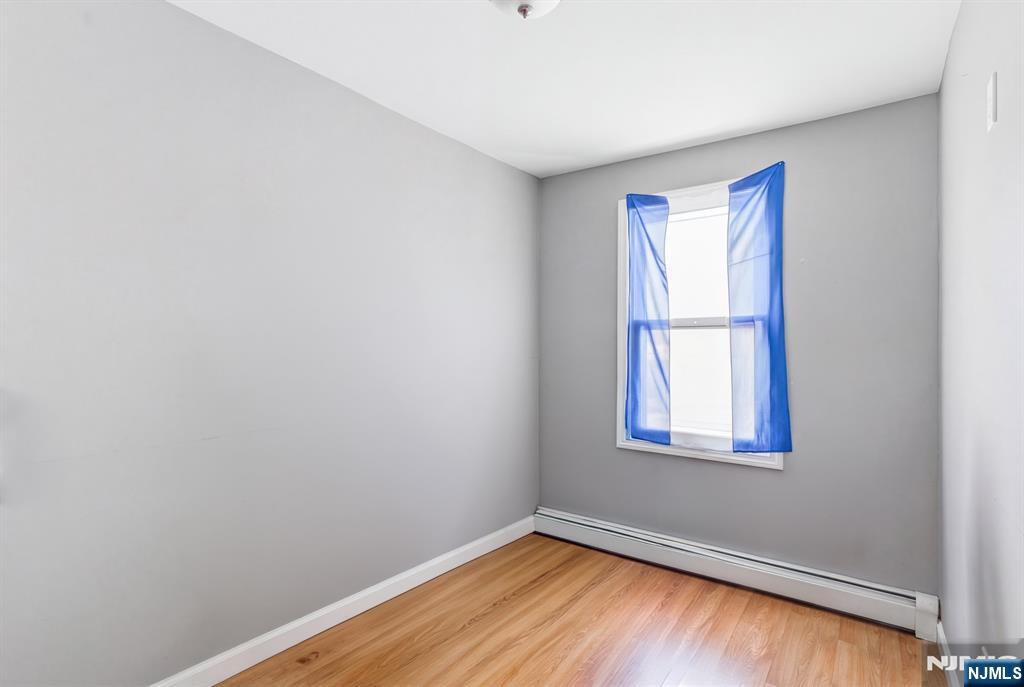 61 Cutler Street Newark, NJ 07104 - Photo 15 of 22 a view of an empty room with wooden floor and a window