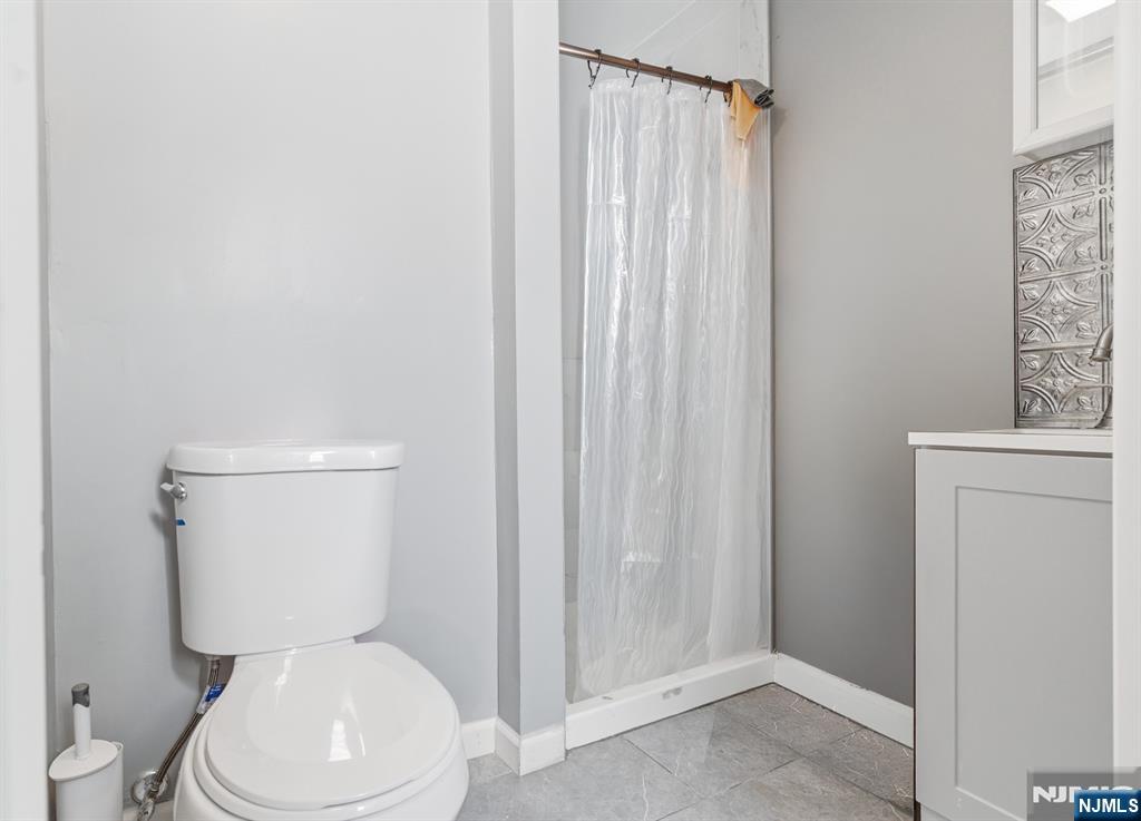 61 Cutler Street Newark, NJ 07104 - Photo 16 of 22 a white toilet sitting next to a shower curtain