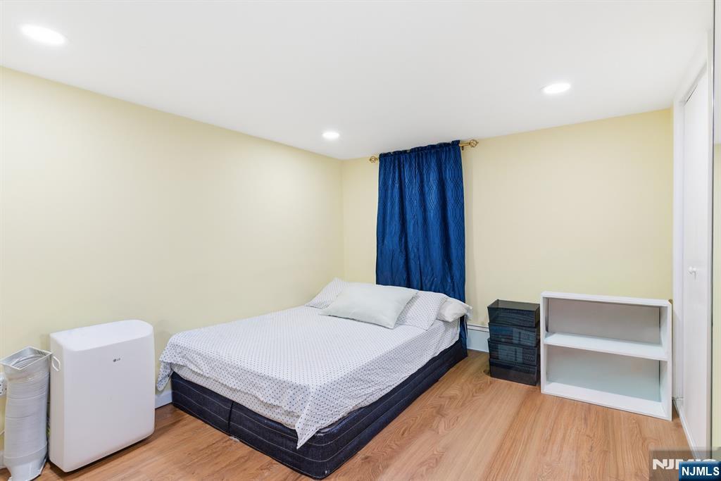 61 Cutler Street Newark, NJ 07104 - Photo 4 of 22 a bed sitting in a spacious bedroom next to a window
