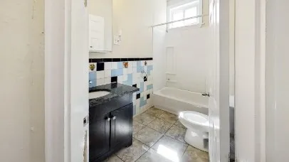 a bathroom with a granite countertop sink mirror vanity and toilet