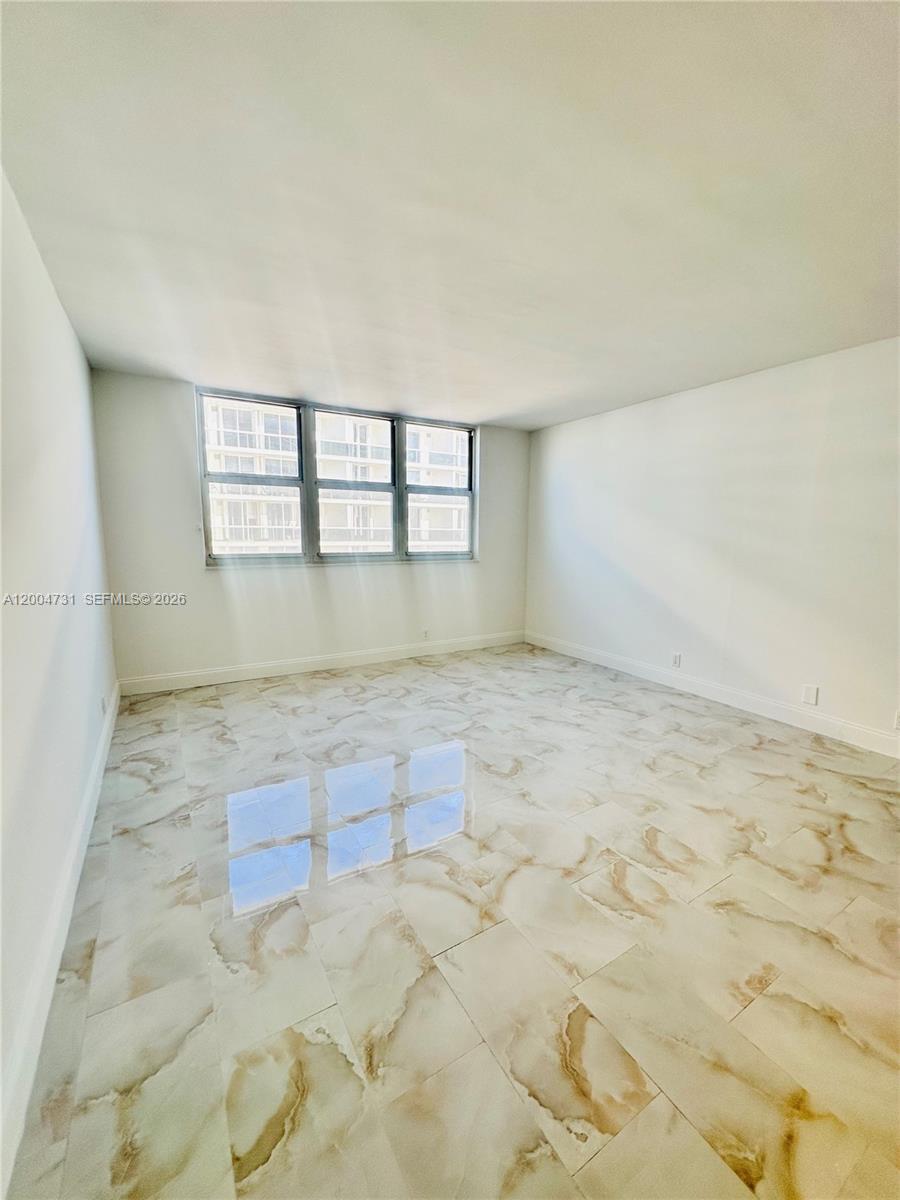 9511 Collins Avenue, Unit 1001 Surfside, FL 33154 - Photo 20 of 34 an empty room with a chandeliers