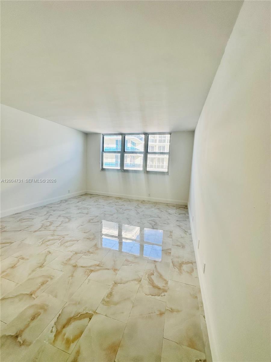 9511 Collins Avenue, Unit 1001 Surfside, FL 33154 - Photo 21 of 34 an empty room with windows