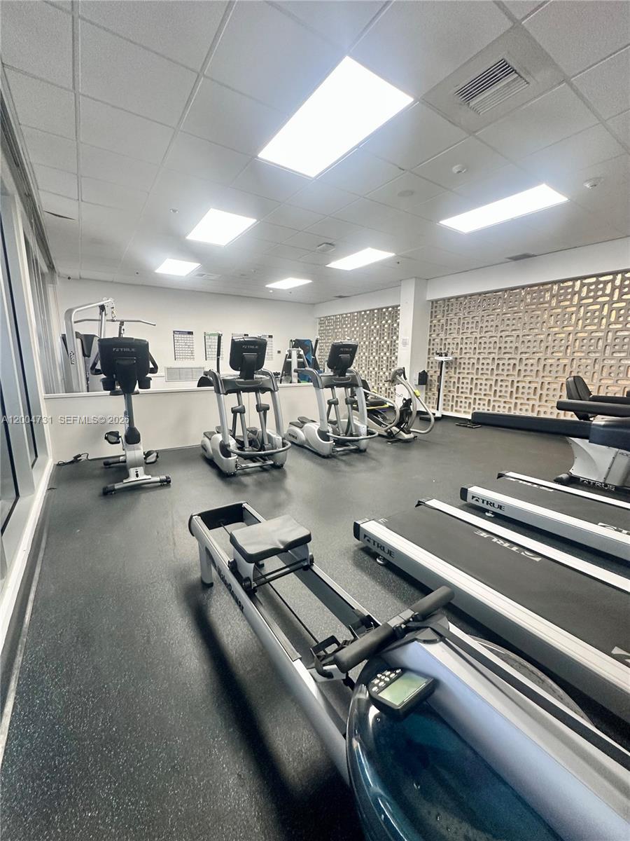 9511 Collins Avenue, Unit 1001 Surfside, FL 33154 - Photo 25 of 34 a room with gym equipment and a large window
