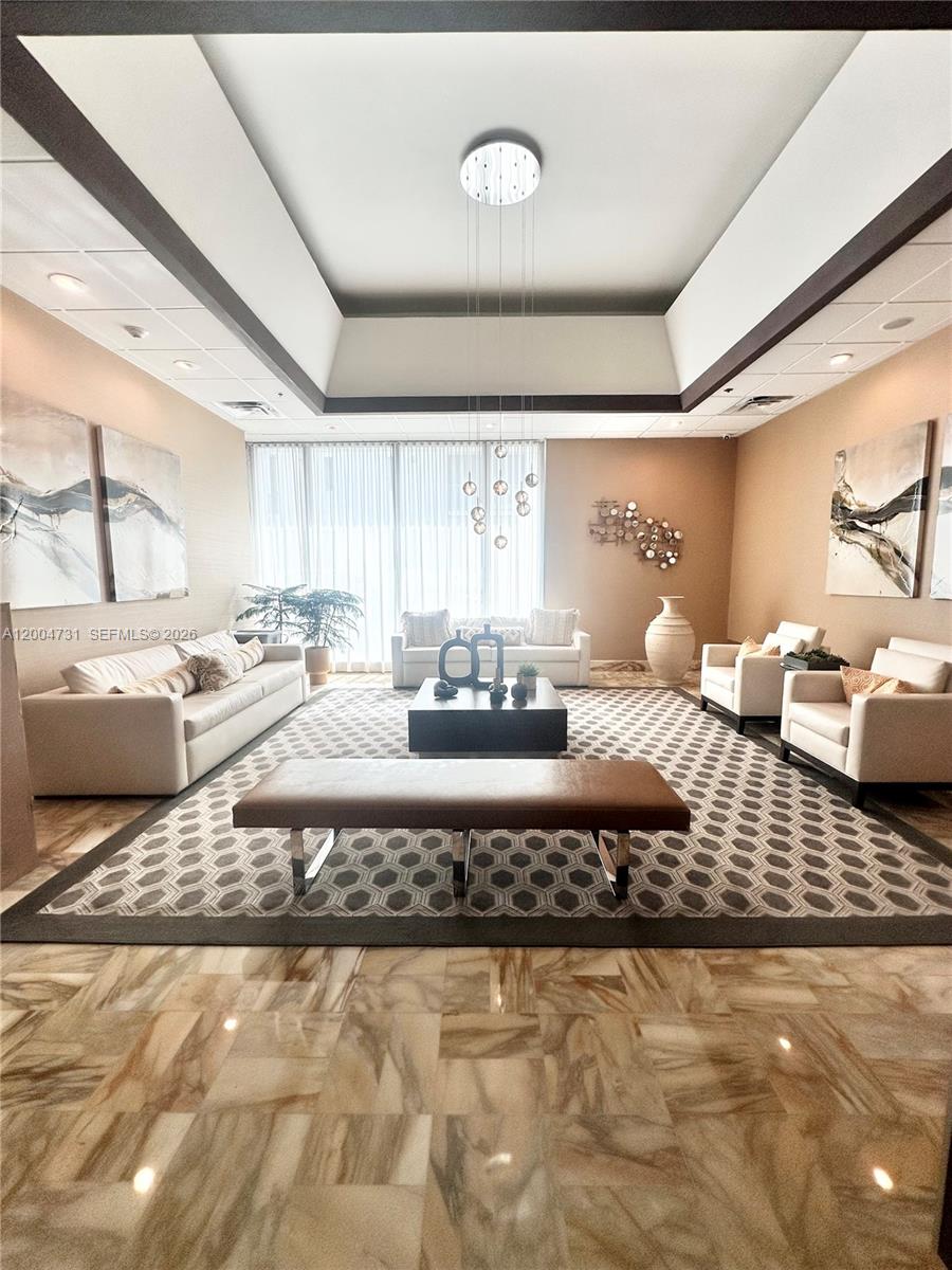 9511 Collins Avenue, Unit 1001 Surfside, FL 33154 - Photo 6 of 34 a living room with a couch and a table