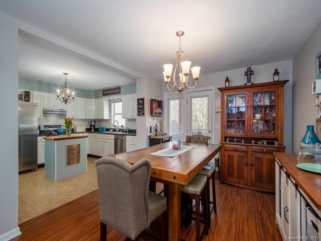 30 North Ridge Point, Unit T3 Sylva, NC 28779 - Photo 7 of 18 a kitchen with stainless steel appliances granite countertop a sink dishwasher a stove a refrigerator a dining table and chairs with wooden floor