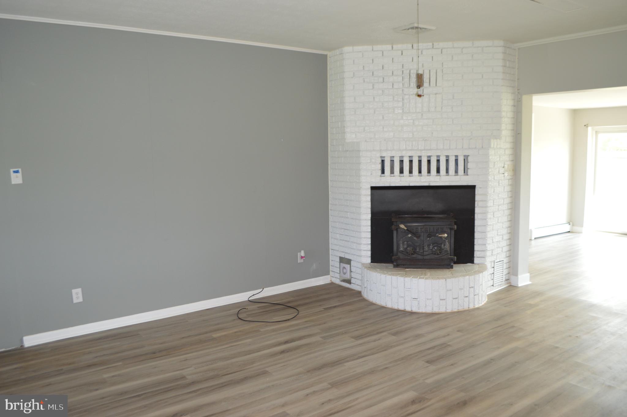 2051 Stover Road Taneytown, MD 21787 - Photo 15 of 44 a view of an empty room with wooden floor and fireplace