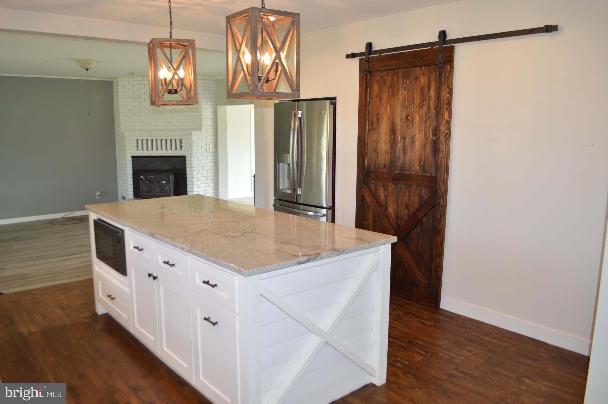 2051 Stover Road Taneytown, MD 21787 - Photo 25 of 44 a kitchen with stainless steel appliances granite countertop a refrigerator a stove and a wooden floors