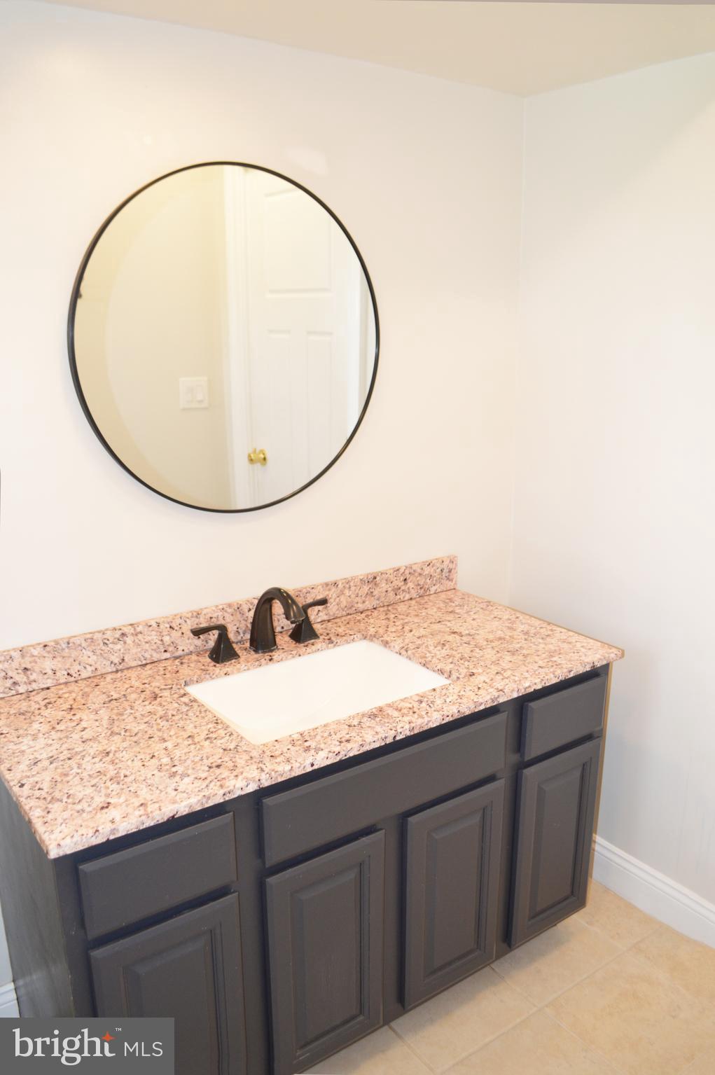 2051 Stover Road Taneytown, MD 21787 - Photo 42 of 44 a bathroom with a granite countertop sink and a mirror