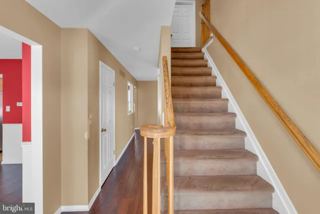 a view of staircase with wooden floor and white walls