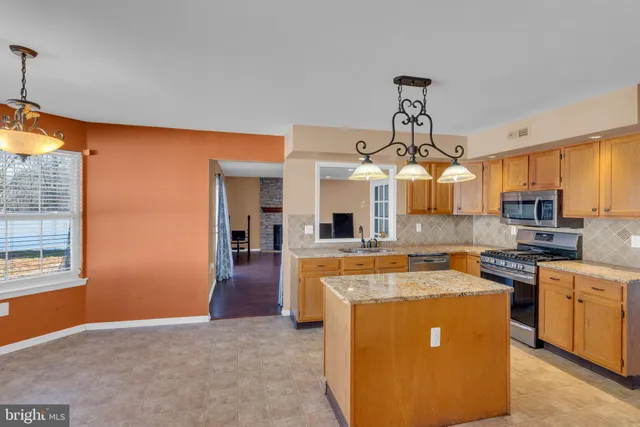 a kitchen with stainless steel appliances granite countertop a sink a stove and a refrigerator