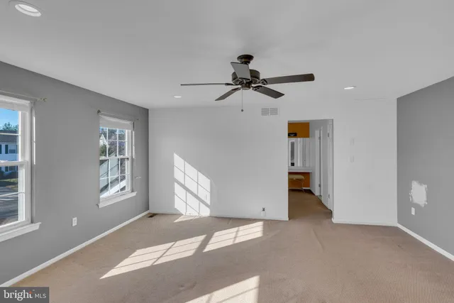 a view of a livingroom with a ceiling fan and window