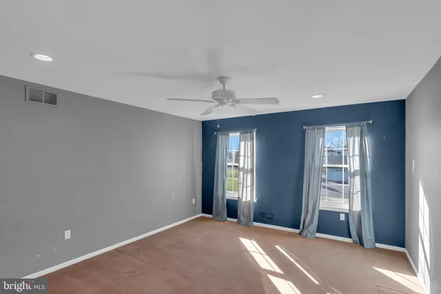 a view of a big room with windows and chandelier fan